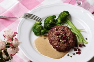 Beef burgers with cream sauce and broccoli