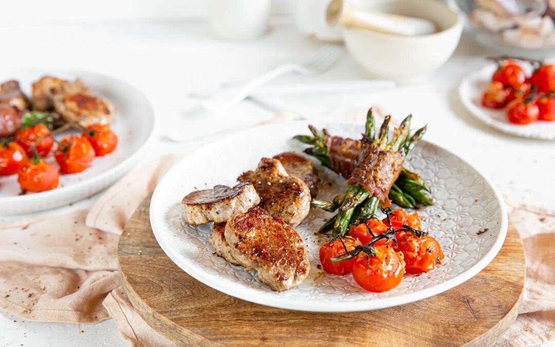 Pan-seared pork loin with bacon-wrapped green beans and baked tomatoes